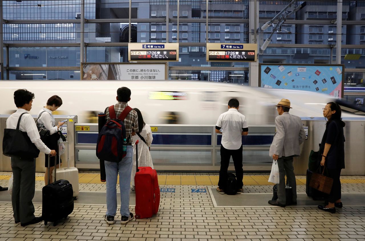 Passengers prepare to board a Shinkansen bullet train in Kyoto, Japan.